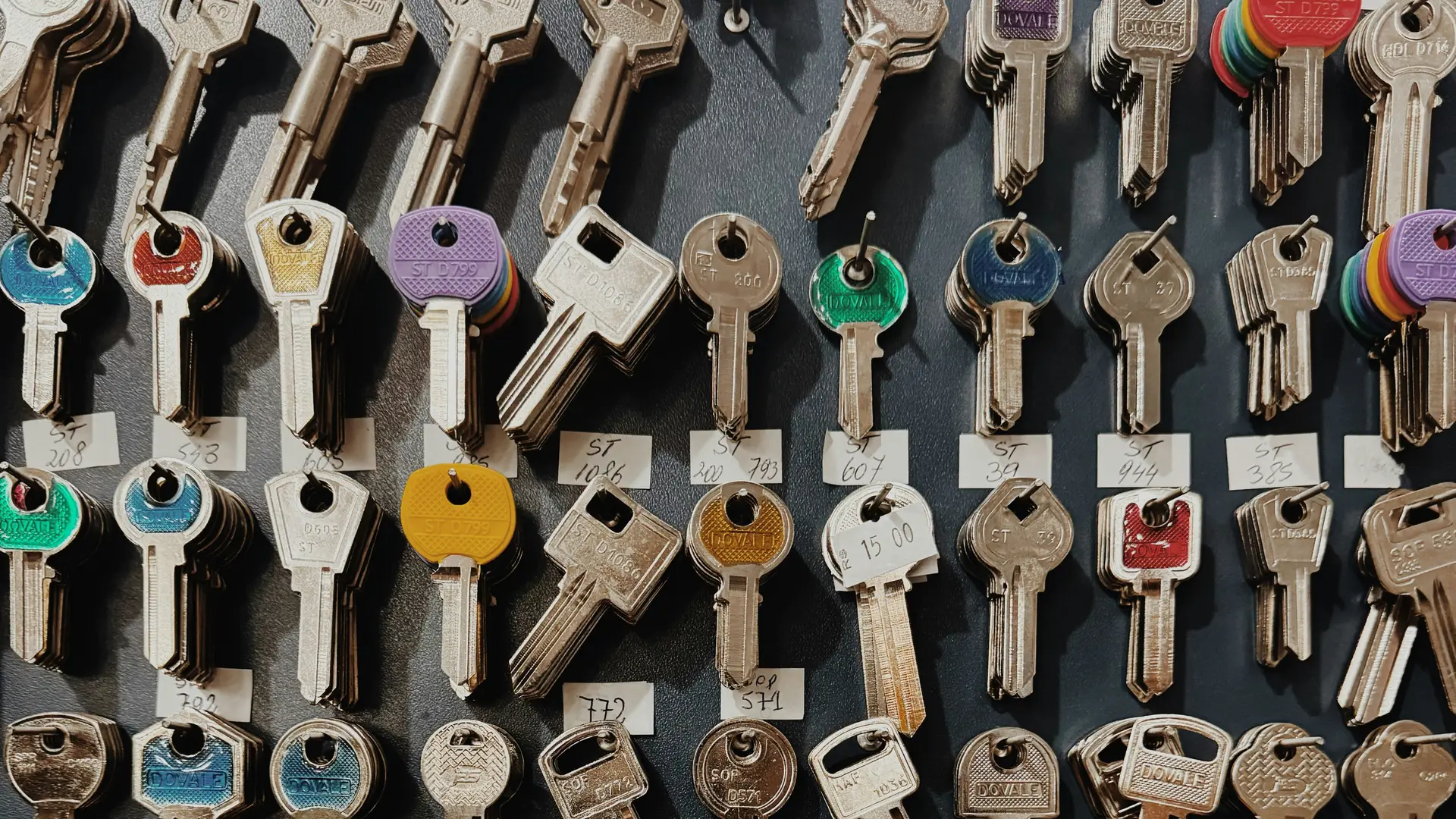 A wall displaying many different keys, neatly arranged and labelled.